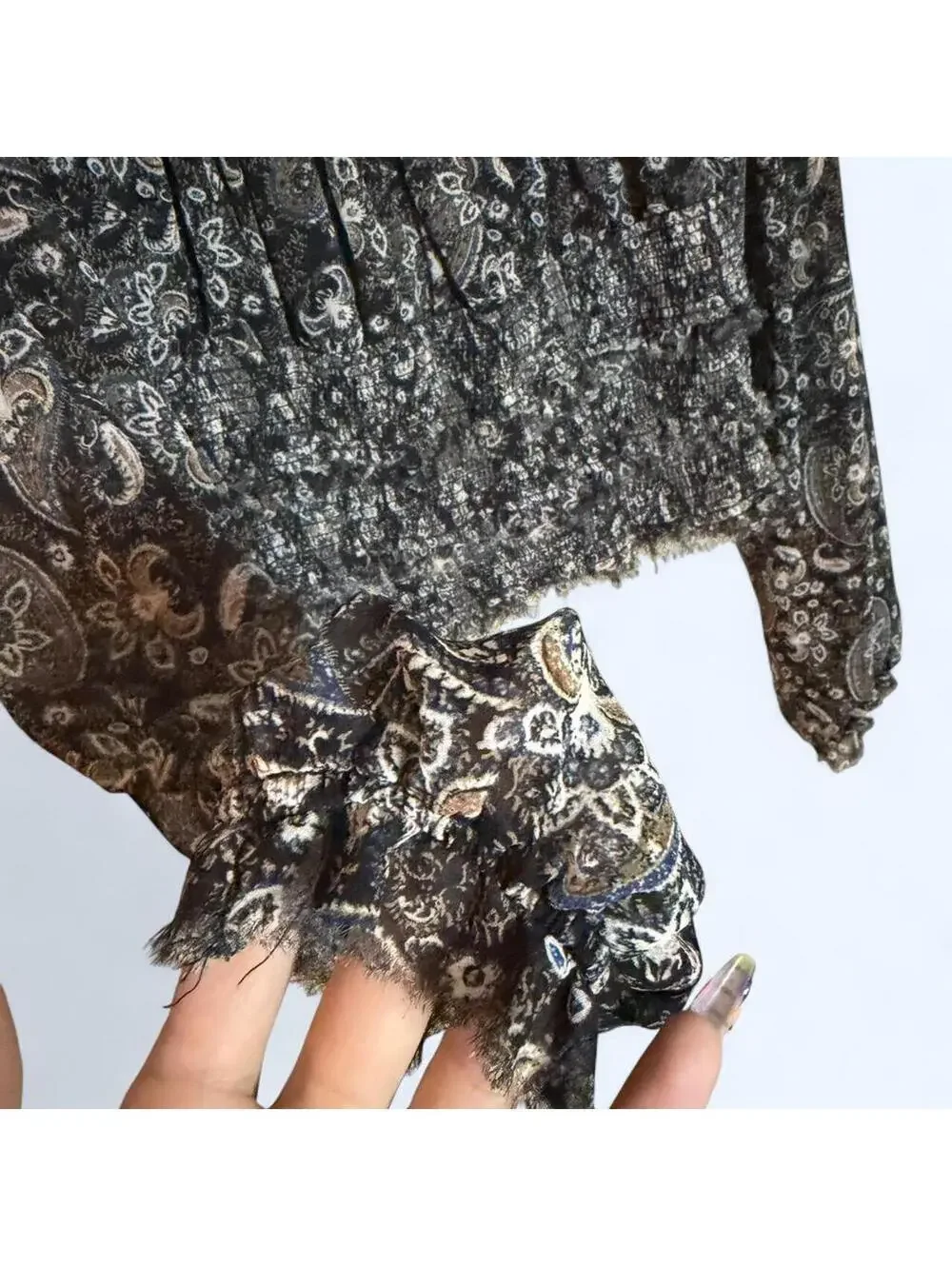Black and grey paisley print blouse with long sleeves and ruffled hem